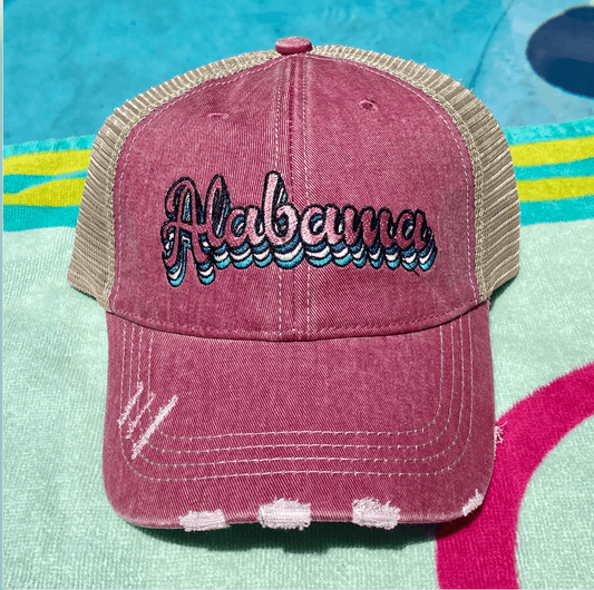 a pink hat with the word albema embroidered on it