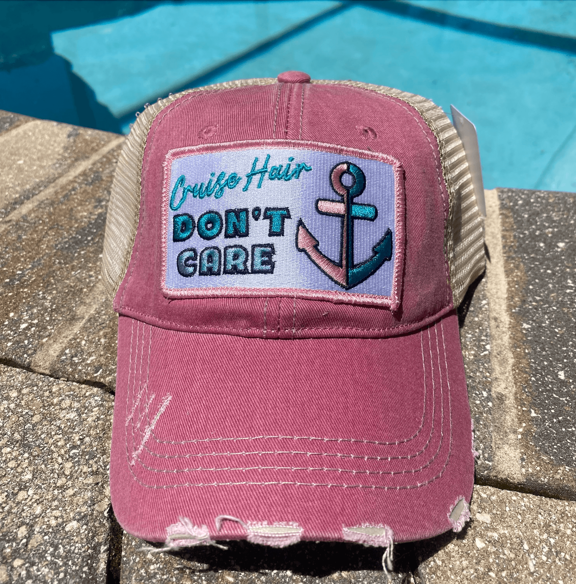 a pink trucker hat with a picture of an anchor on it