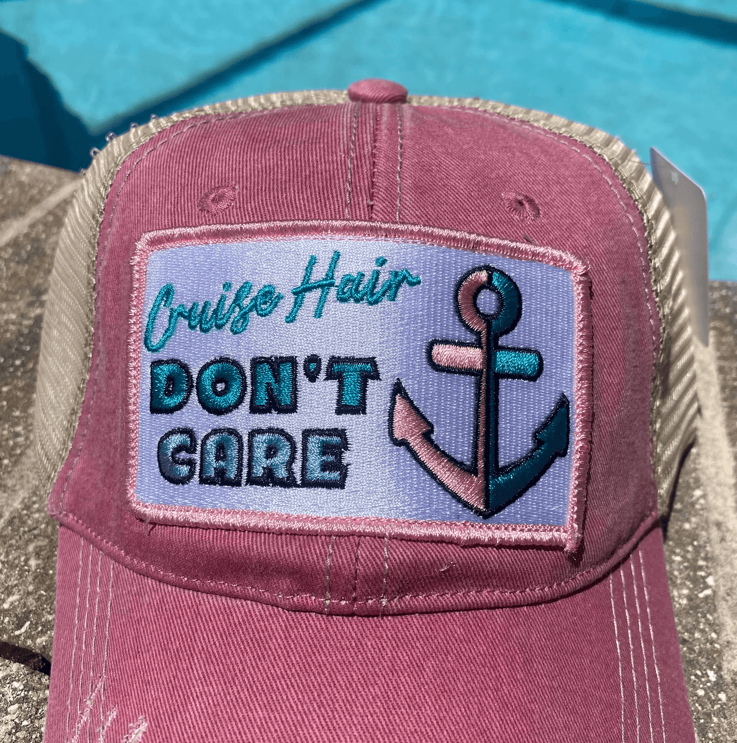 a pink trucker hat with an anchor on it