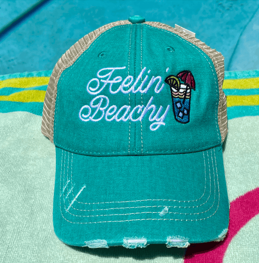 a green hat with a fishin beach embroidered on it