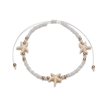 a white beaded bracelet with starfish charms